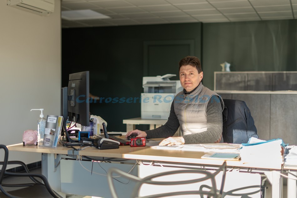 Sébastien Gehin, dirigeant de la Carrosserie Rossion, accueillant ses clients à son bureau.